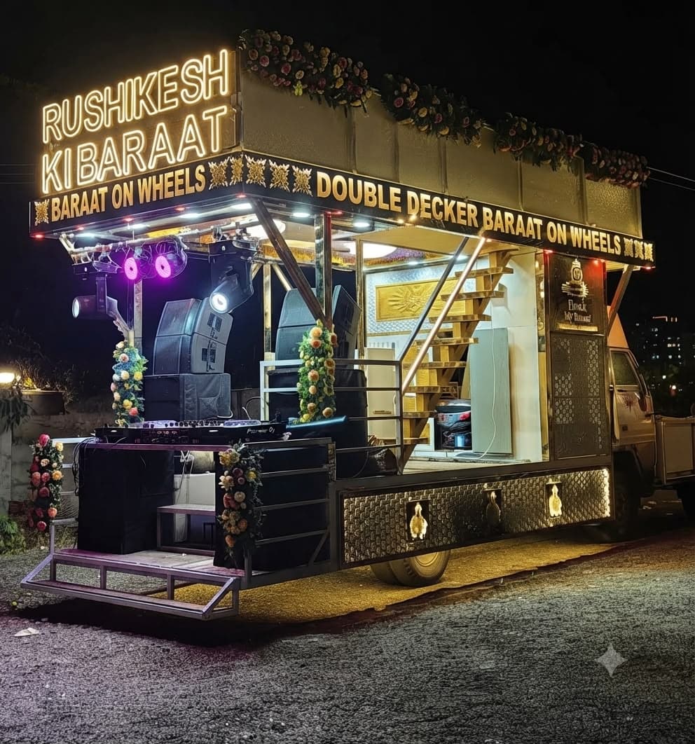 Double-decker baraat-on-wheels DJ truck lit up at night with neon signage and floral trim