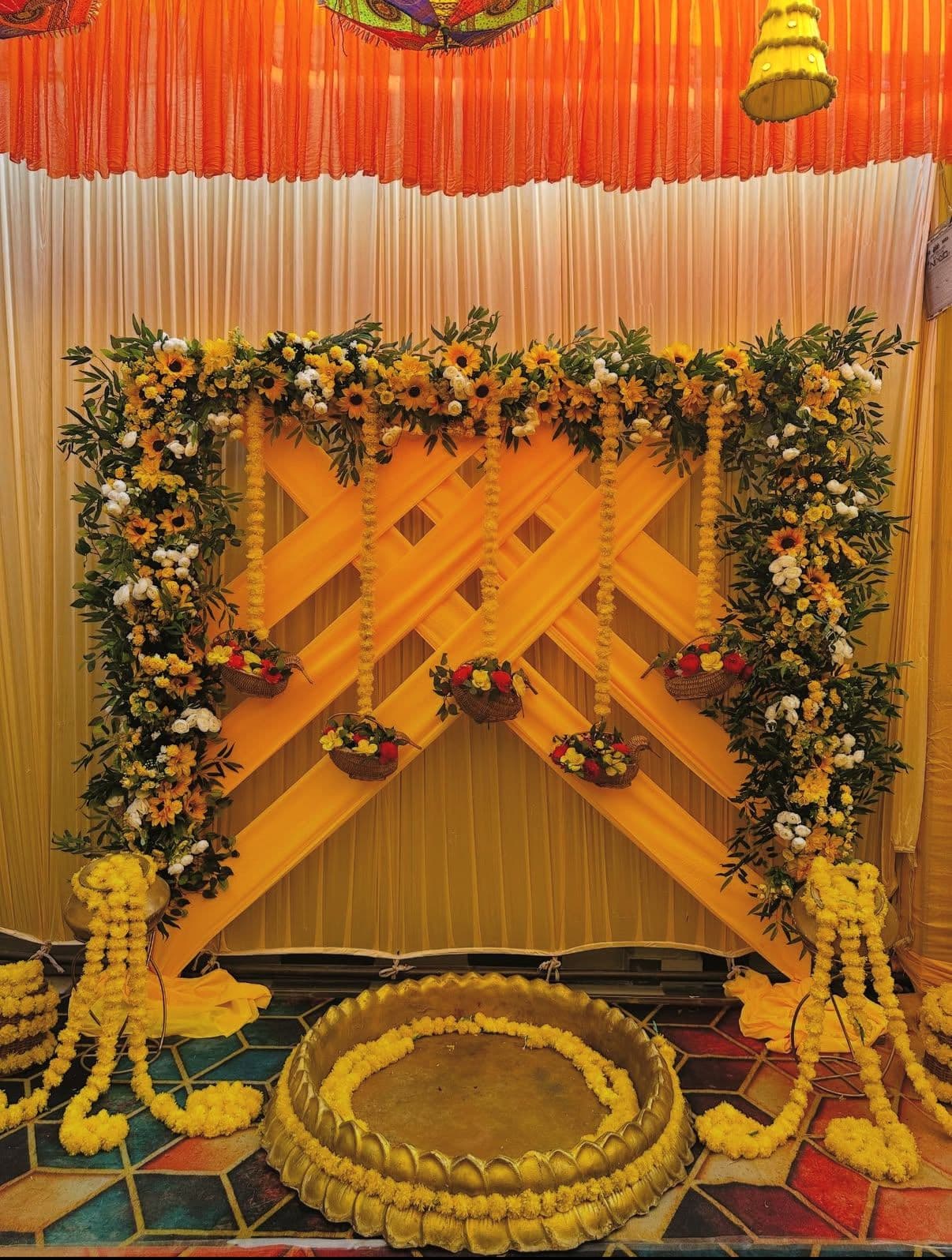 Haldi setup with a sunflower and marigold arch